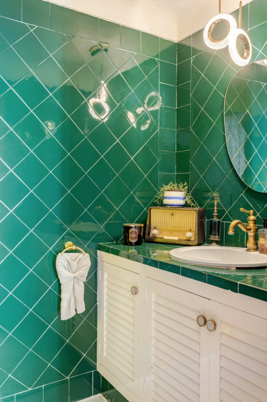 Green-tiled bathroom with vintage radio