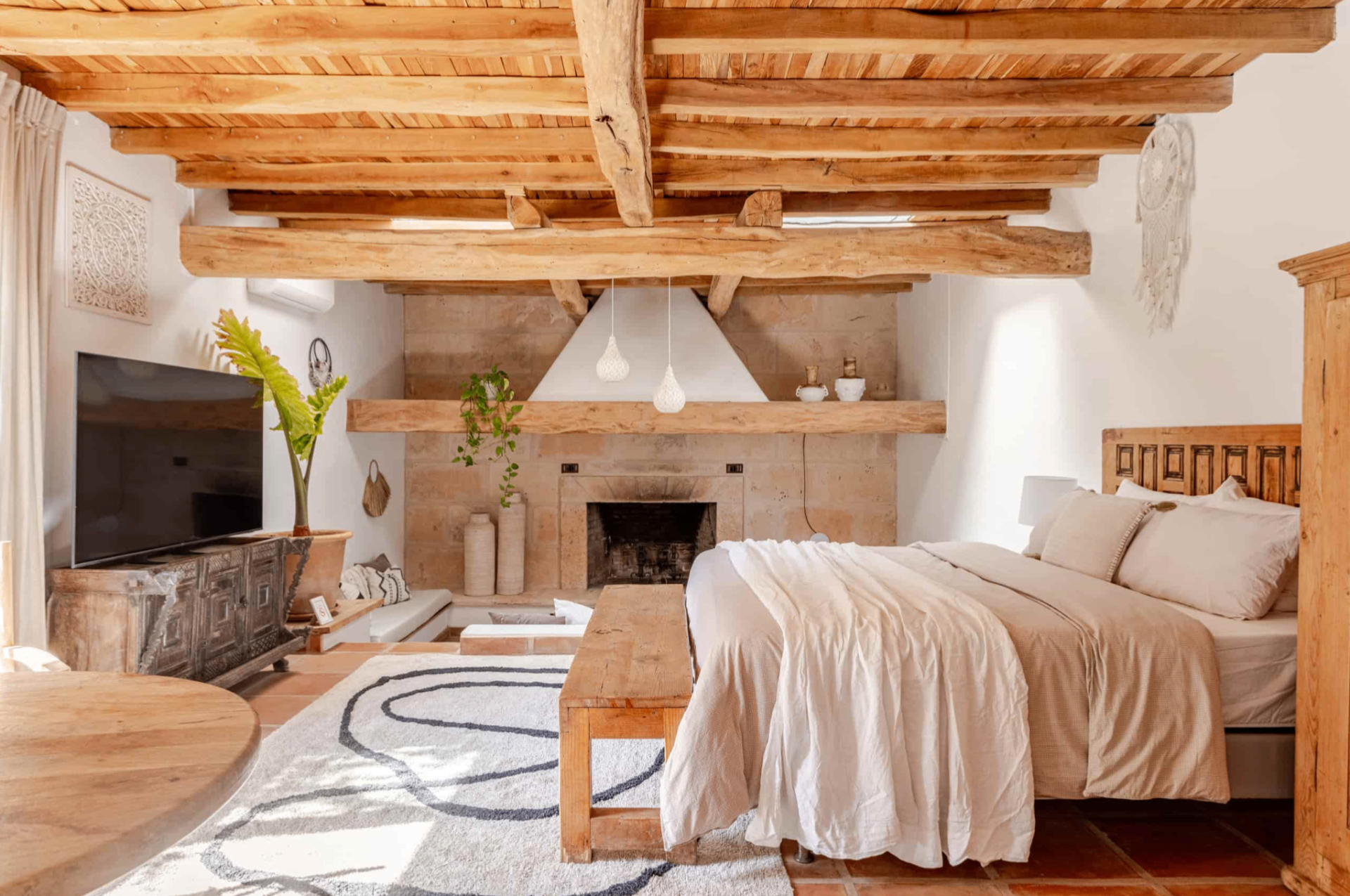 Bedroom with stone fireplace and timber ceiling